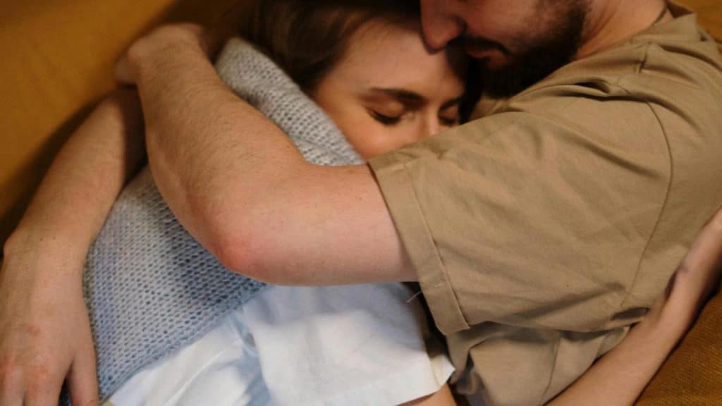 A couple embracing closely on a couch.