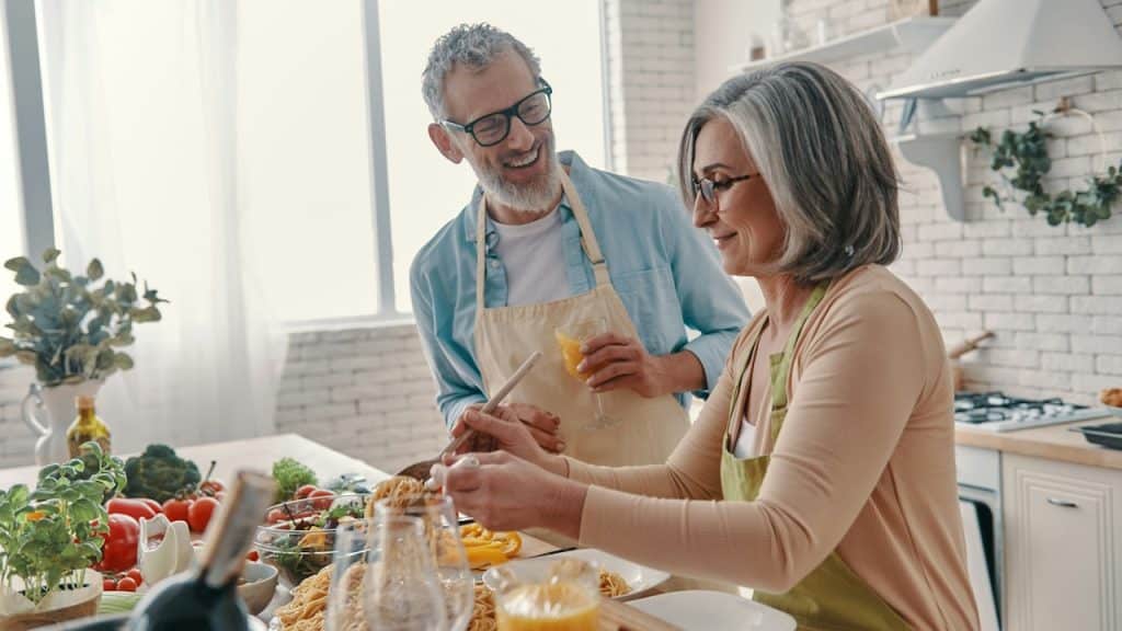 A couple cooking together in the kitchen.