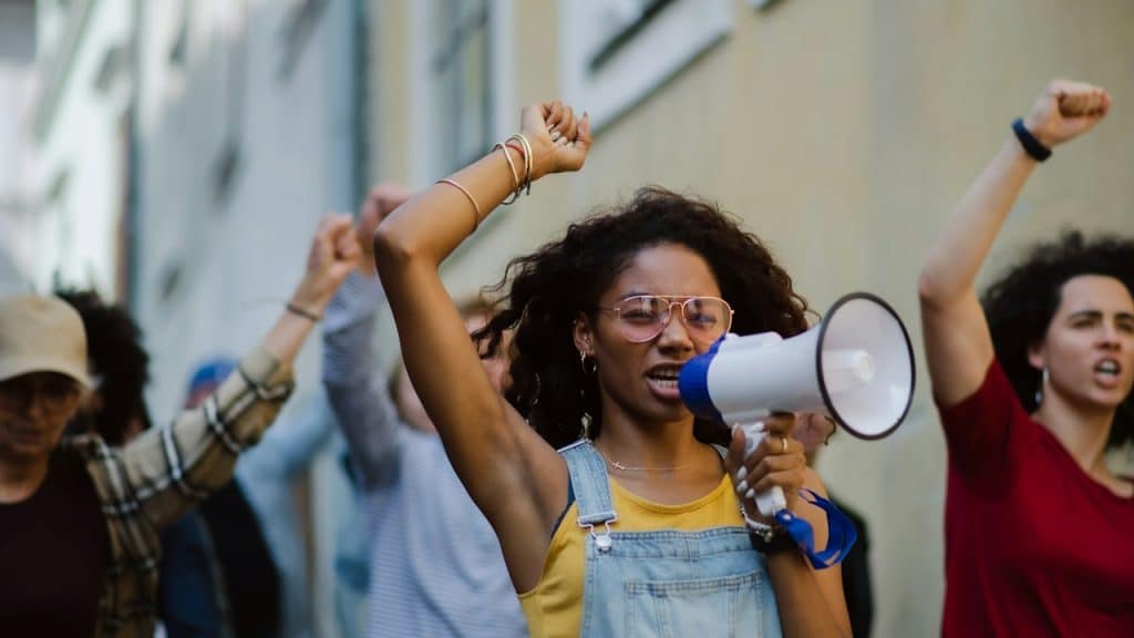 A group of people activists with megaphones protesting on the streets.