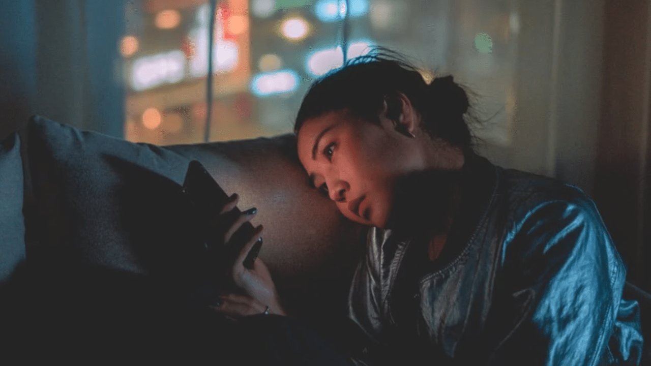 A woman looking sad while using her phone