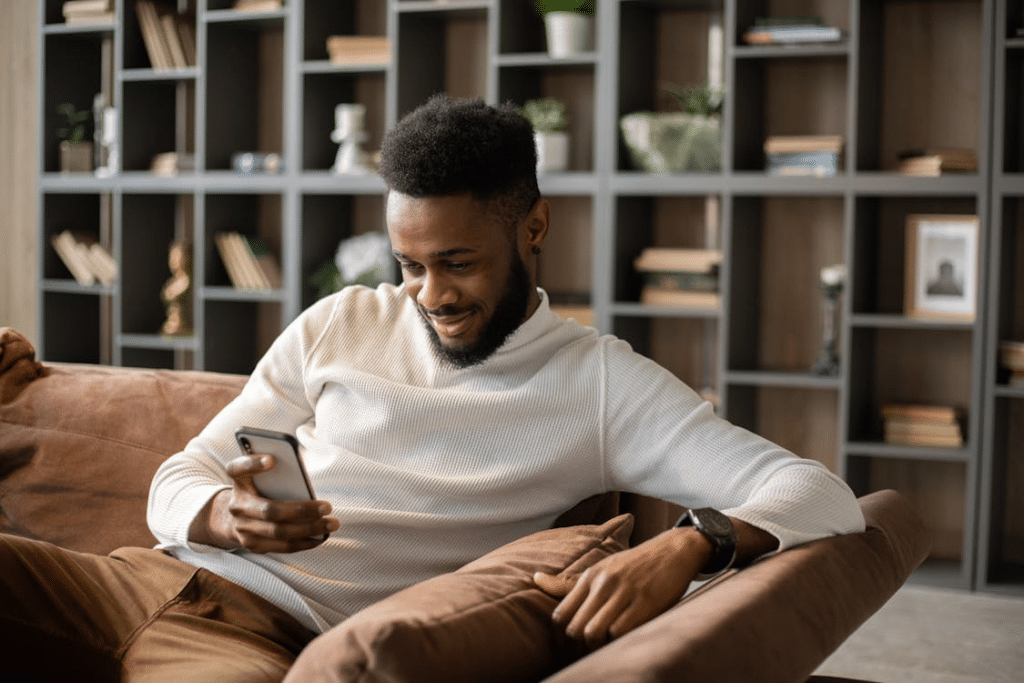 Smiling young black man having video call at home