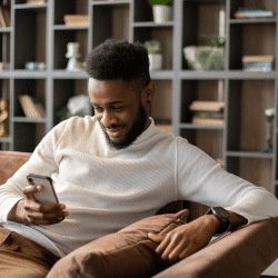 Smiling young black man having video call at home