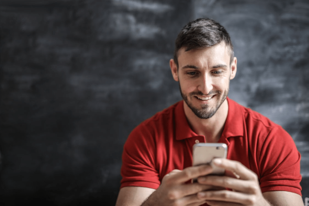 Man in Red Polo Shirt Holding a Phone