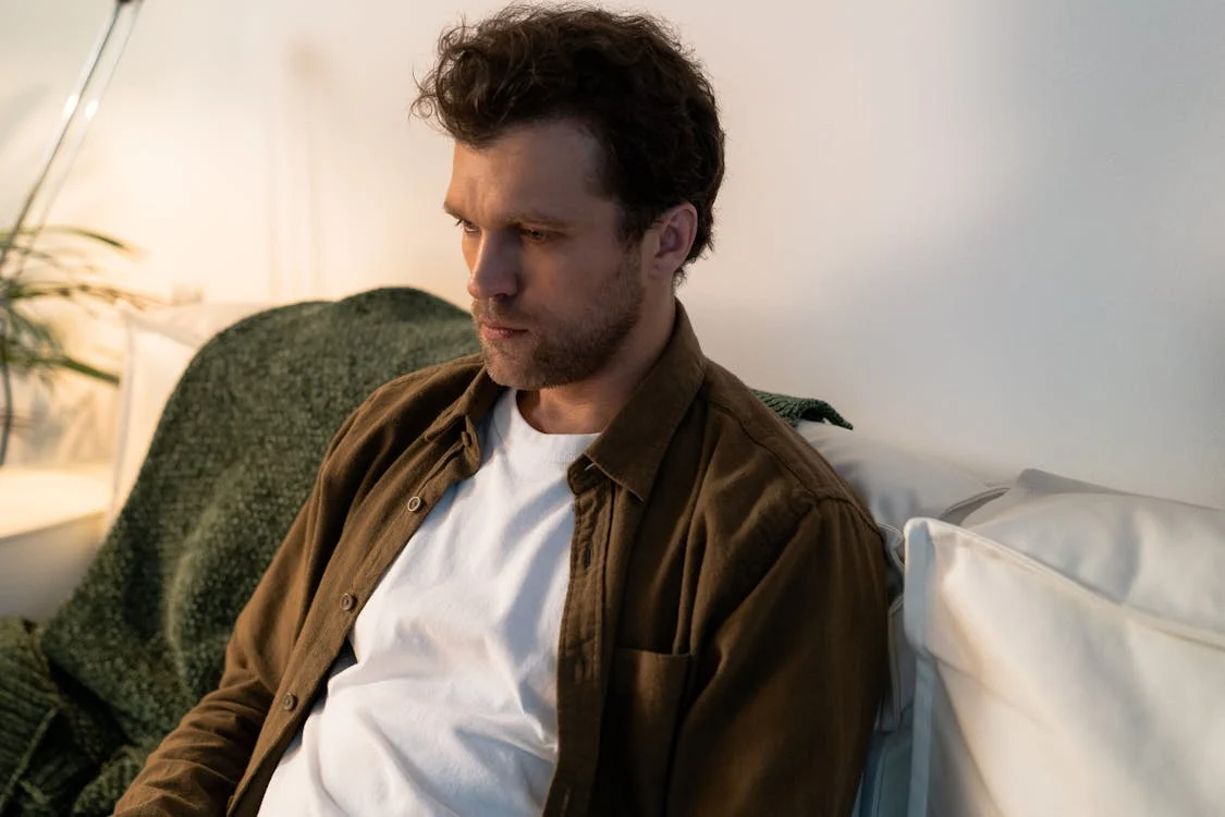 A sad man sitting on a sofa