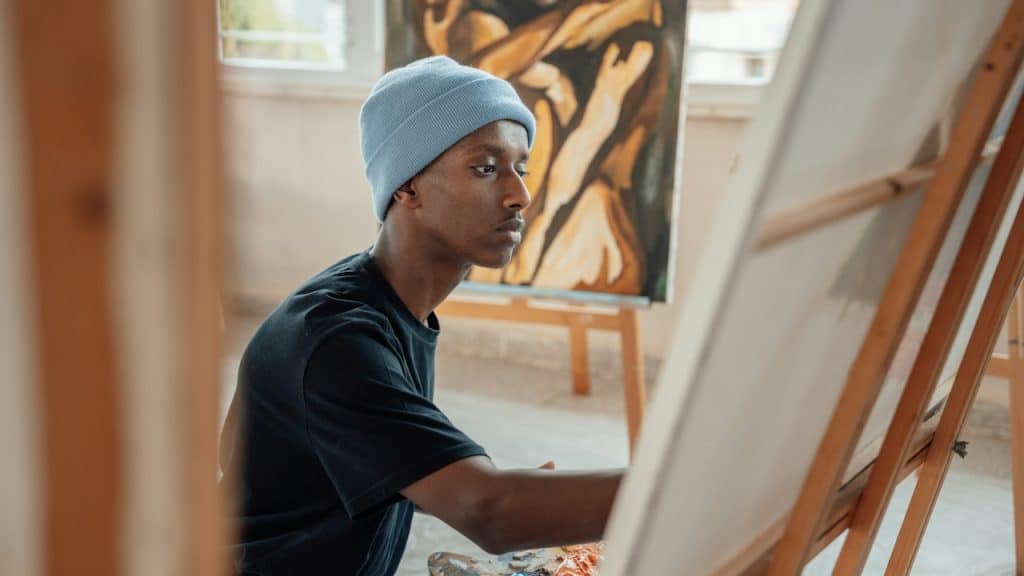 A man painting on a canvas.