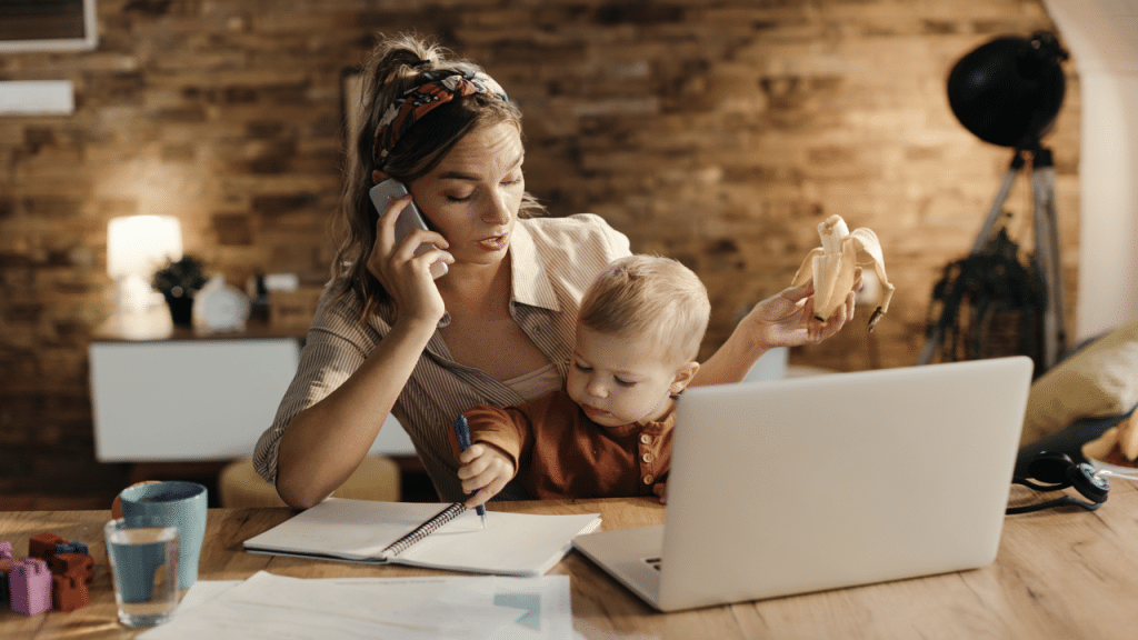 A mom on the phone while taking care of her baby