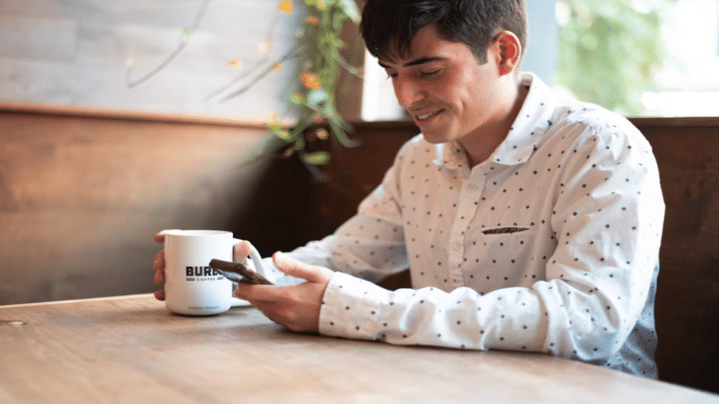 A man smiling while texting