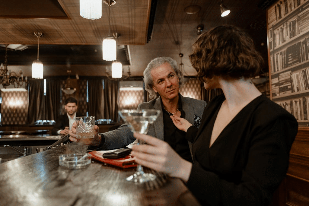 An older man talking to a younger woman in a bar