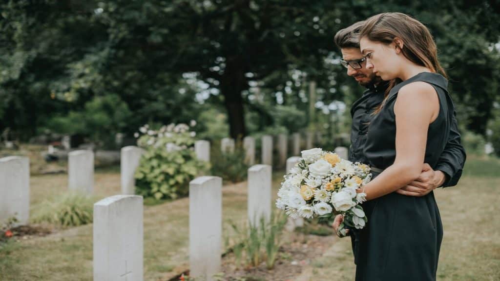 A couple visiting a gravestone