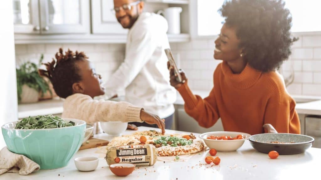A family preparing food together in a bright kitchen.