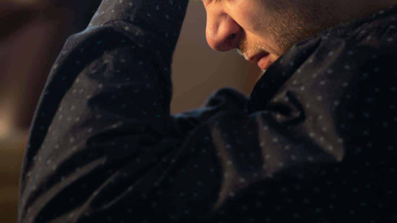 A man holding his head with a stressed expression.