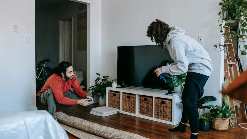 A couple unrolling a rug together in their living room.