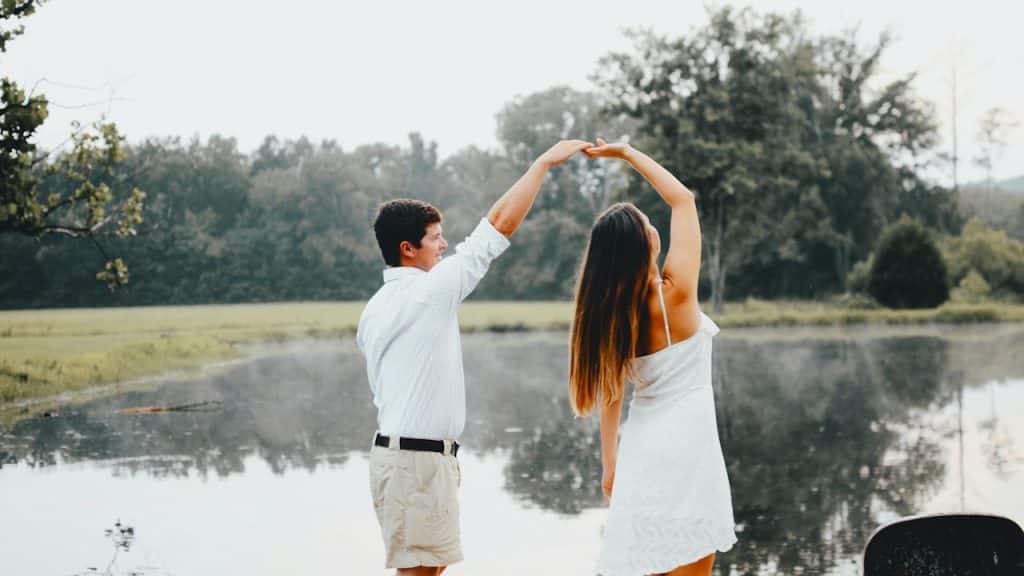 A man and woman dancing near a body of water.