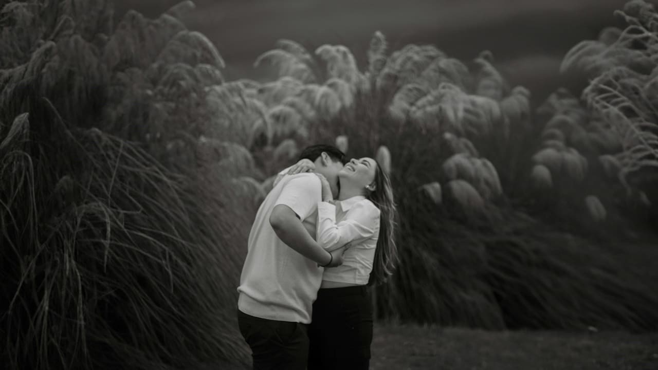 A grayscale image of a man and a woman hugging each other.