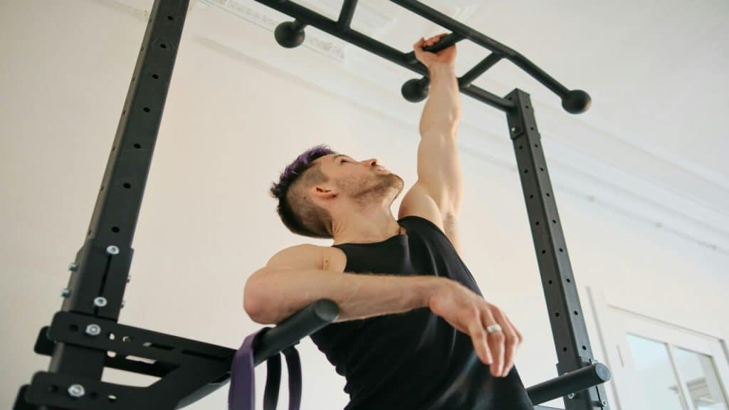 A man doing pull-ups at the gym