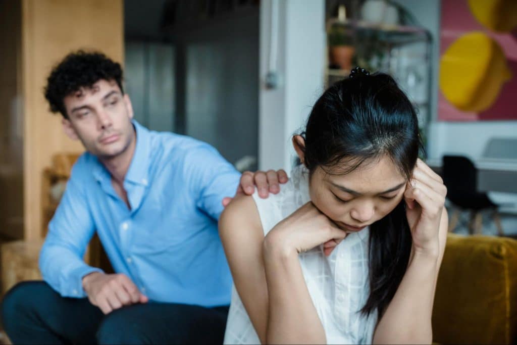 A man reaching for woman’s shoulder