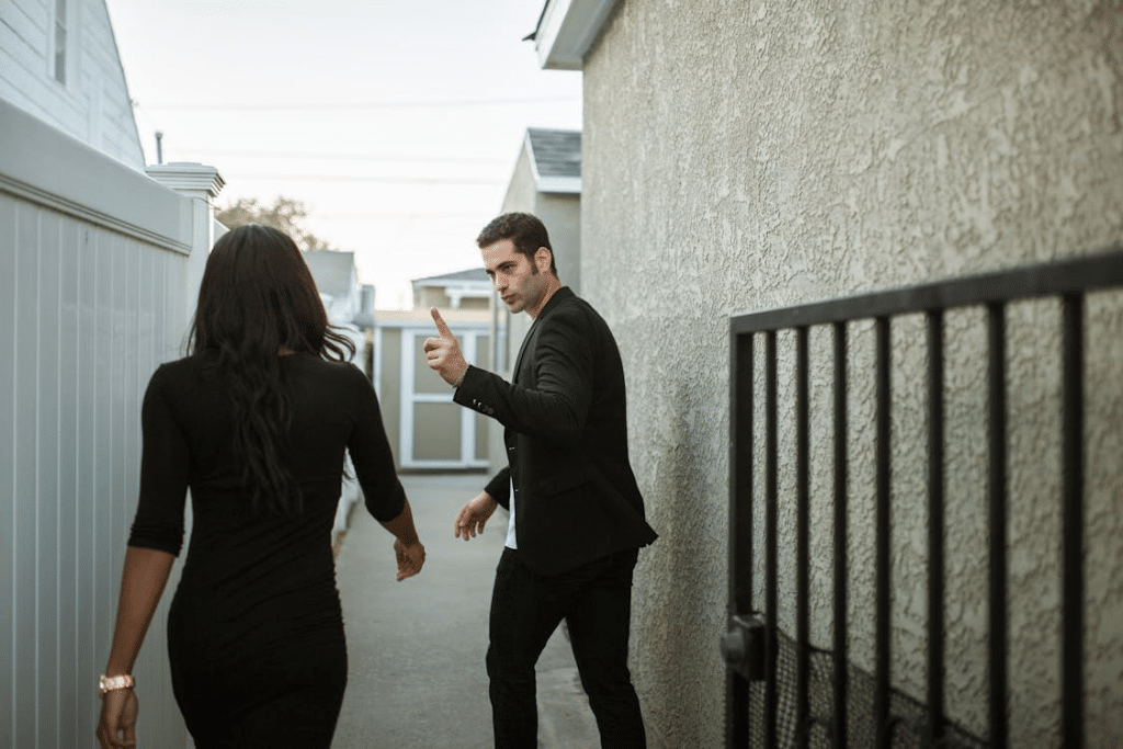 Man in Black Suit Jacket and Black Pants Standing Beside Woman in Black Long Sleeve Shirt