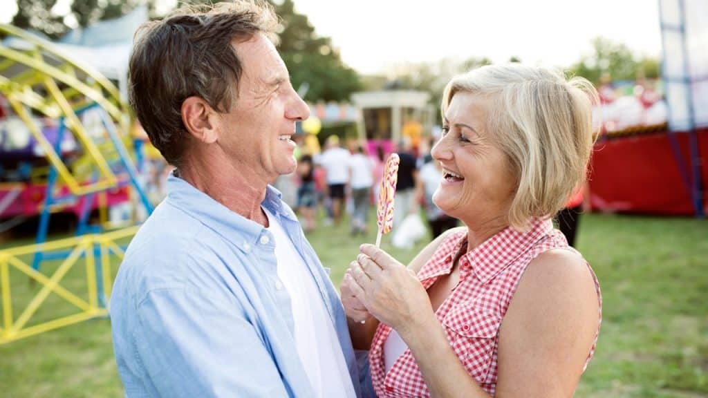 A couple having a good time at a funfair.