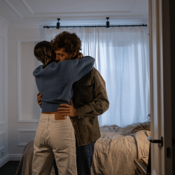 A Couple Hugging Each Other in a Bedroom