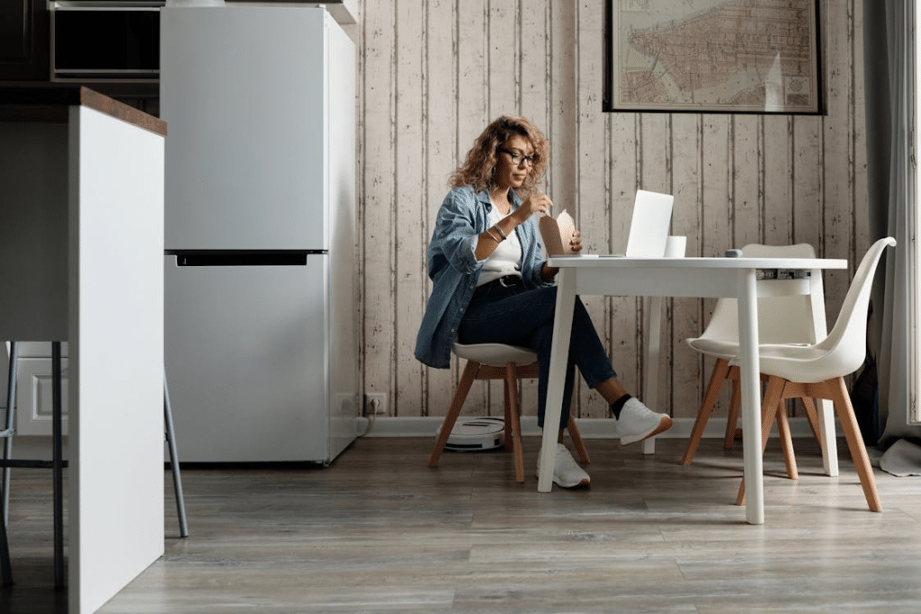 Woman in Blue Shirt Sitting on Chair and Eating Takeaway Food