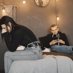 Photo of a woman crying while sitting on a bed