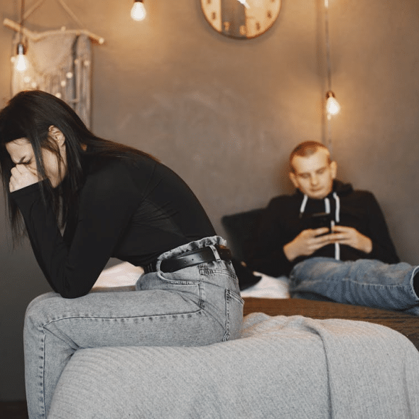 Photo of a woman crying while sitting on a bed