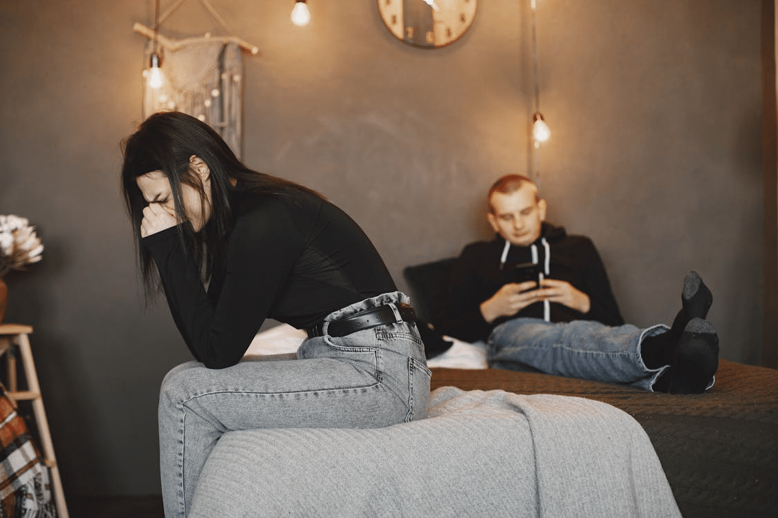 Photo of a woman crying while sitting on a bed