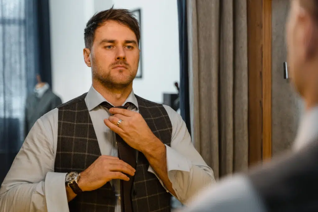 A man dressing up in front of a mirror