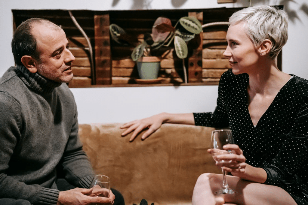 Couple sitting with wineglasses talking to each other