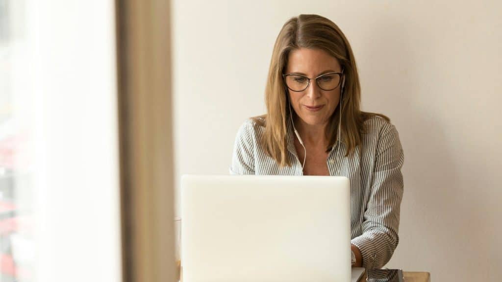 An older woman working on her laptop.