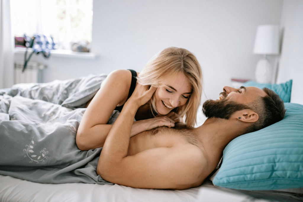 A couple laughing and lying in bed