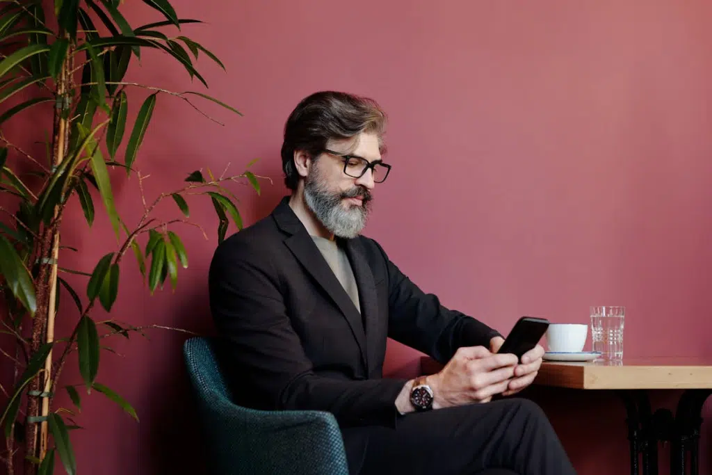 A man sitting at a table texting