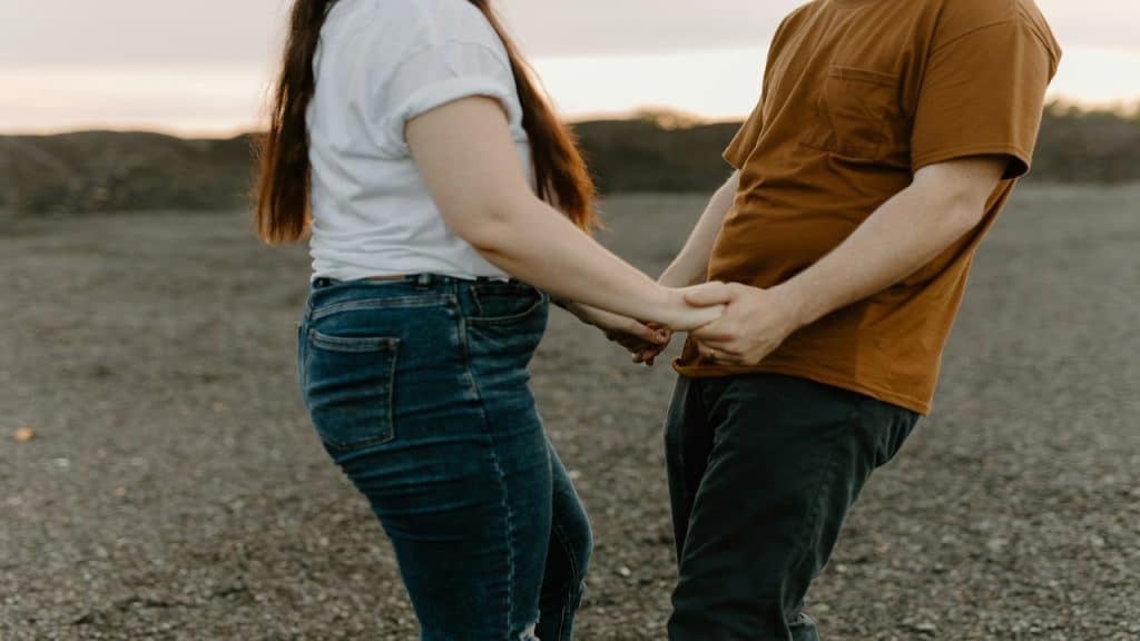 A man and a woman holding each other's hands.