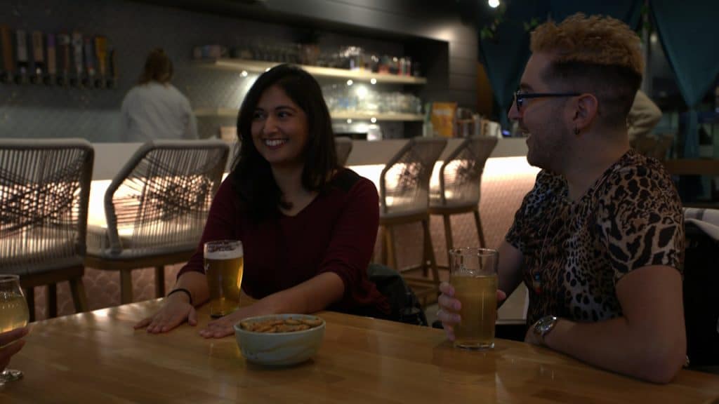 A man and a woman sitting at a table with drinks.