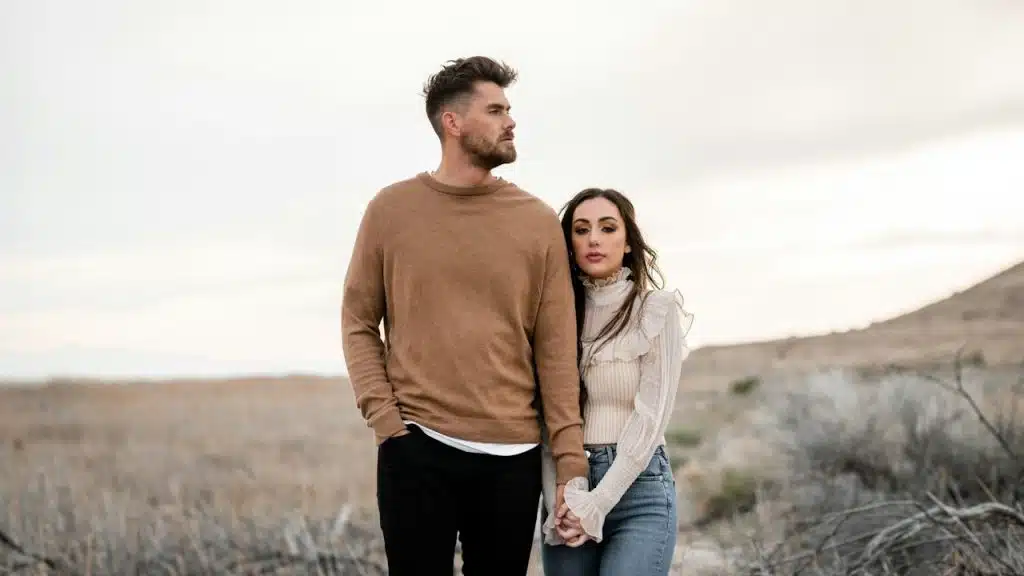 A man and a woman standing in a field.