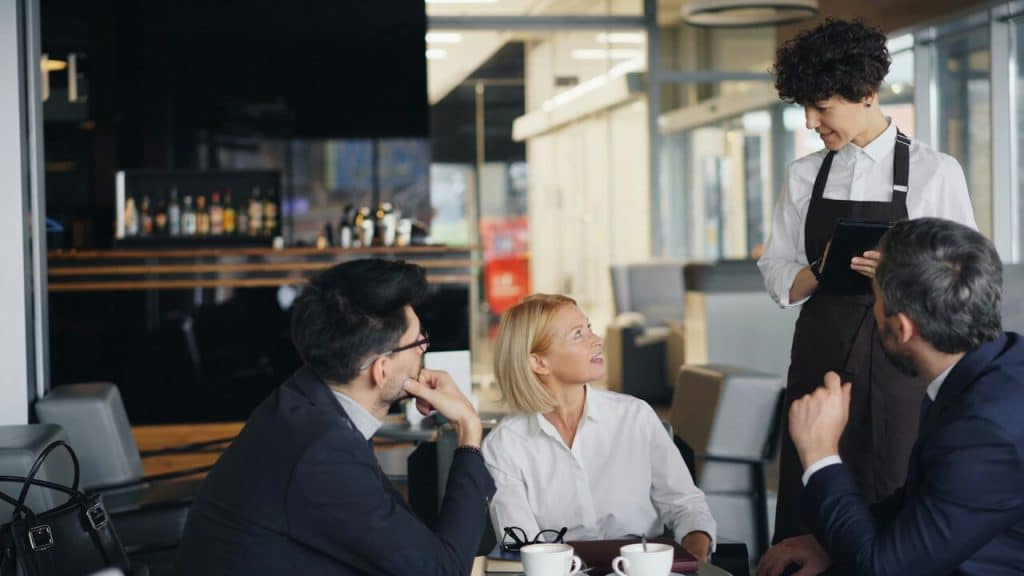 Colleagues talking to a waiter