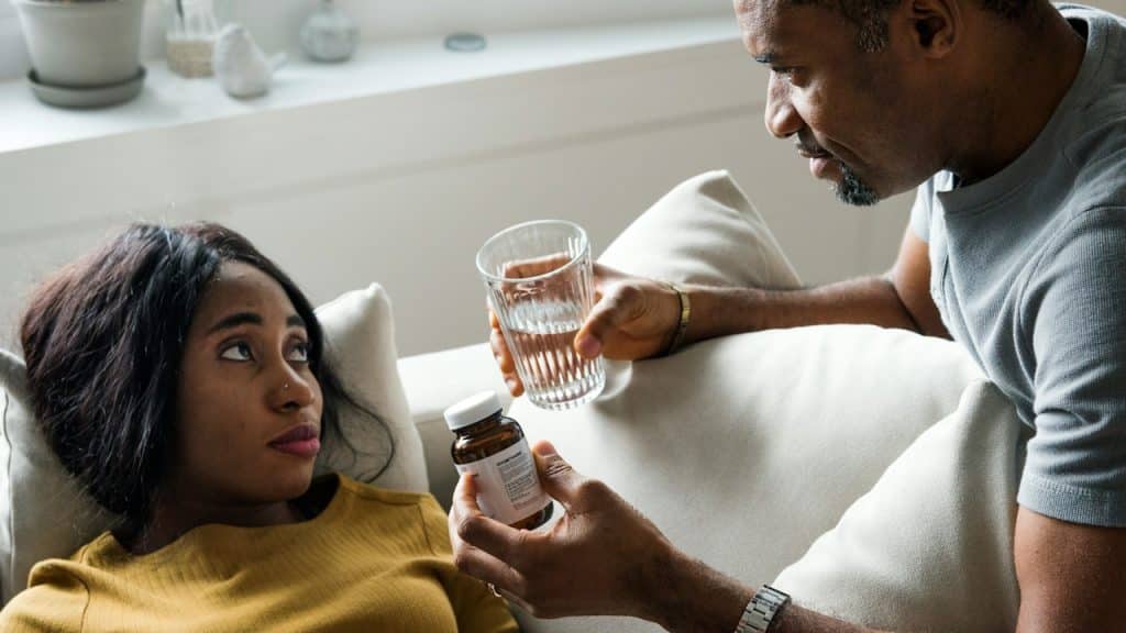 A man giving supplements to his tired wife.