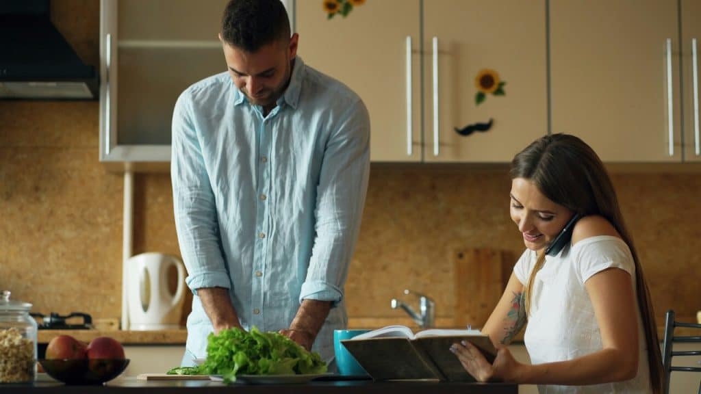 A couple doing chores in the kitchen