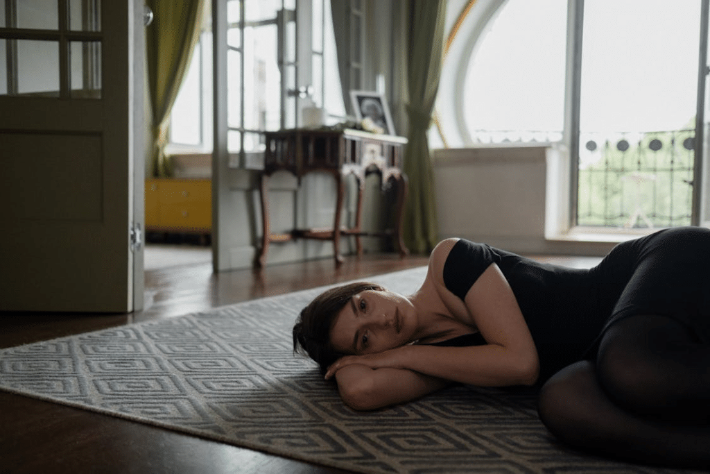 A woman in black dress lying on carpet on the floor