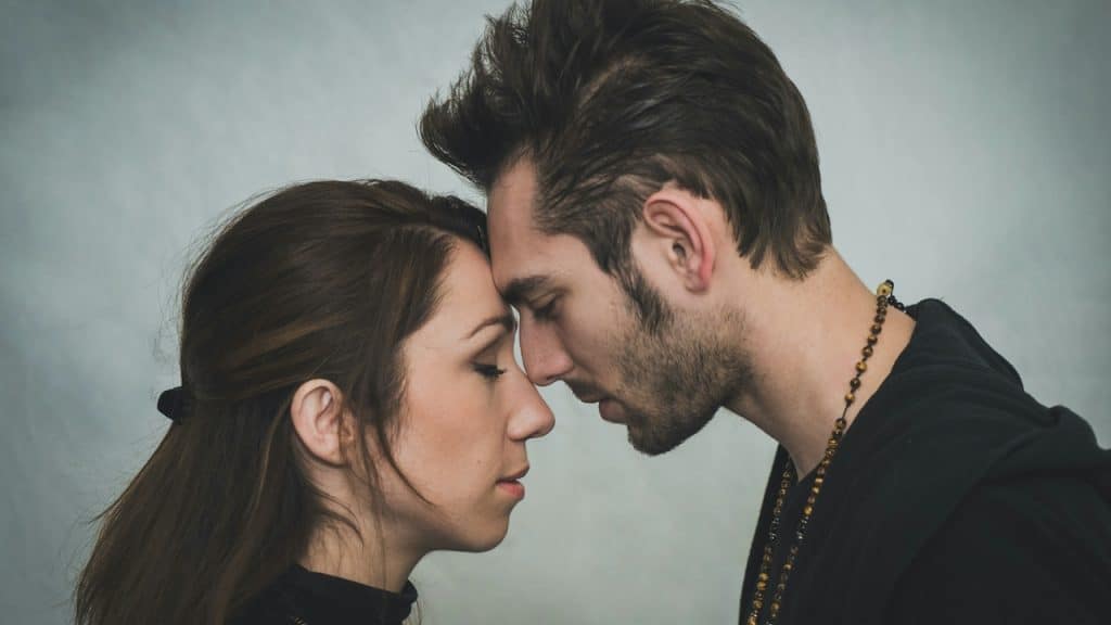 A man touching foreheads with a woman.