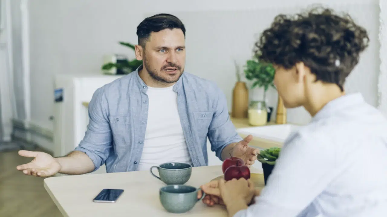 A man berating his wife while they eat 