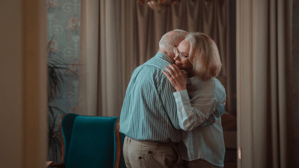 An elderly couple dancing at home