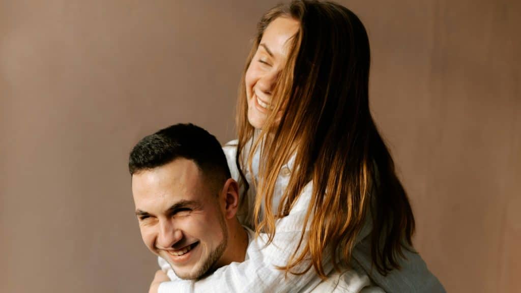 A man holding a woman on her back.