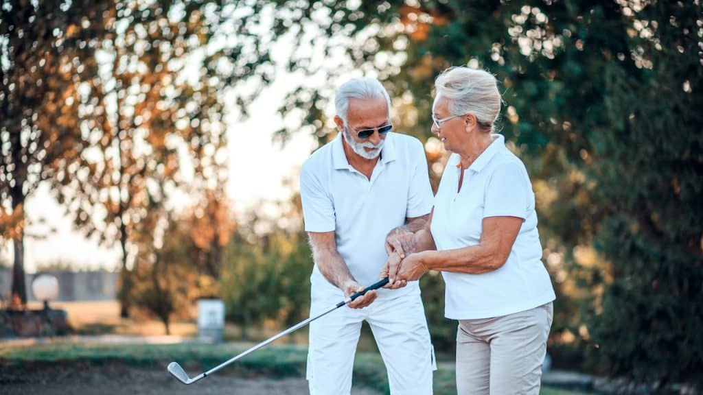 A senior couple playing golf together.