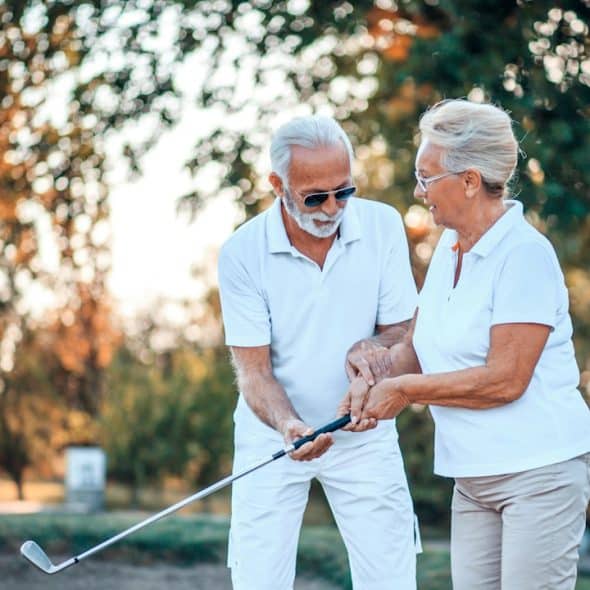 A senior couple playing golf together.