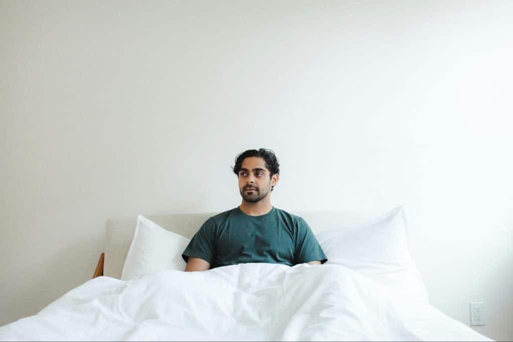 A man sitting alone in the bed