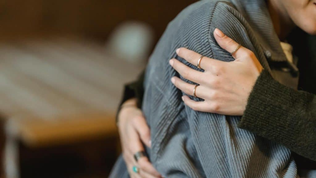A person comforting someone with a gentle hug.
