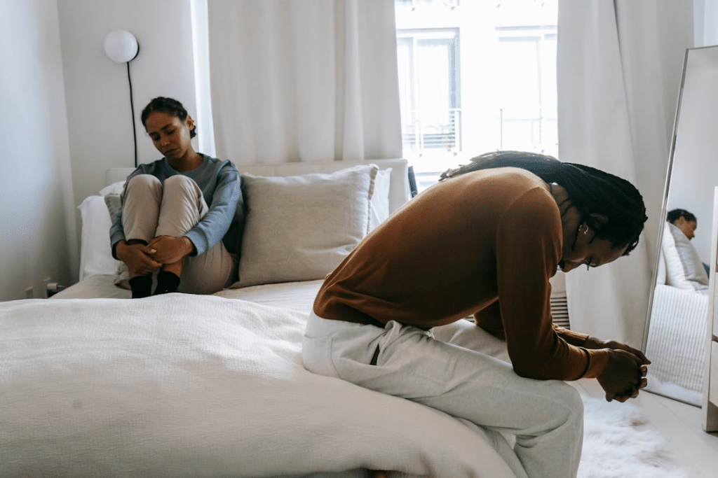 Depressed African American couple on bed during conflict