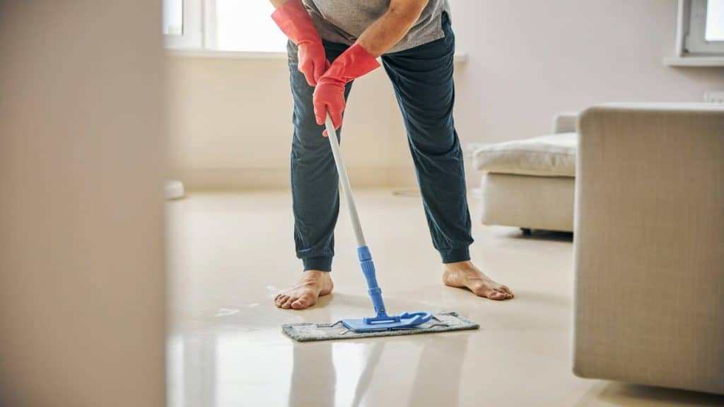 A man mopping the living room