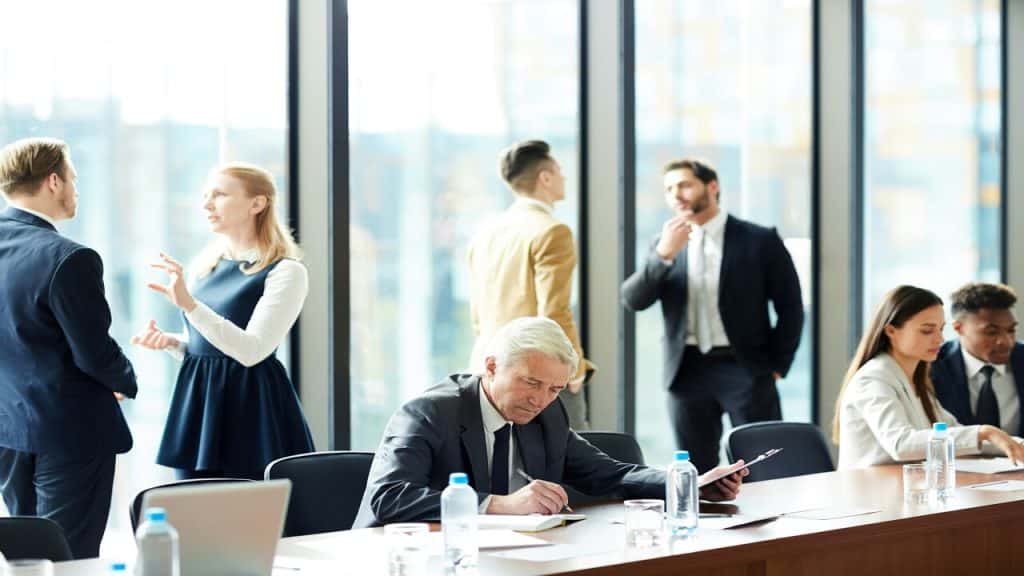 A senior businessman looking calm at a busy office